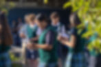 This image links to the Saint Nicholas Catholic School giving portal. It depicts a middle school student holding a candle during the student council swearing in that happens at the beginning of the school year at St. Nicholas School in Los Altos.