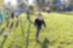 This image links to the Saint Nicholas Catholic School Admissions Policy page. It depicts an elementary school aged  boy chasing a ball on one of the Saint NIcholas School fields at recess. Other children are playing in the background.